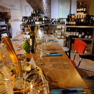 wijnkelder, lange gedekte tafel met glazen en plateau met brood olijfolie