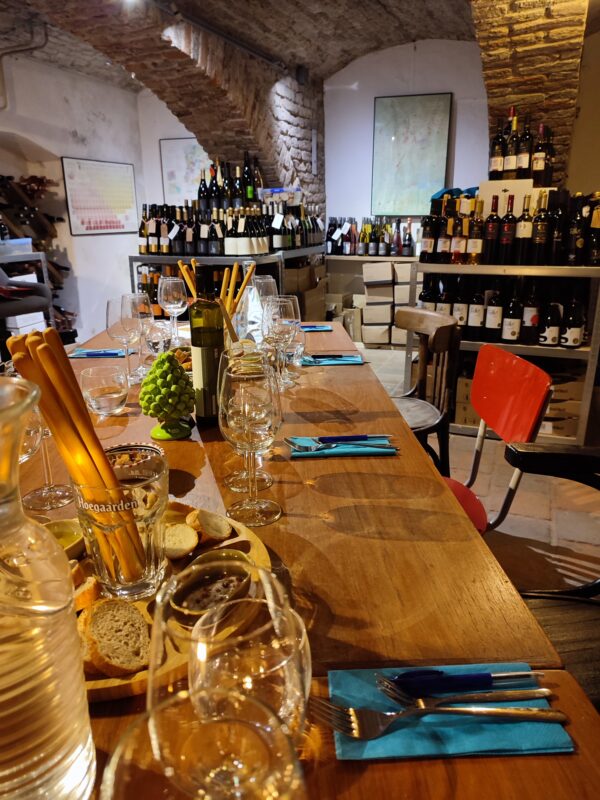 wijnkelder, lange gedekte tafel met glazen en plateau met brood olijfolie